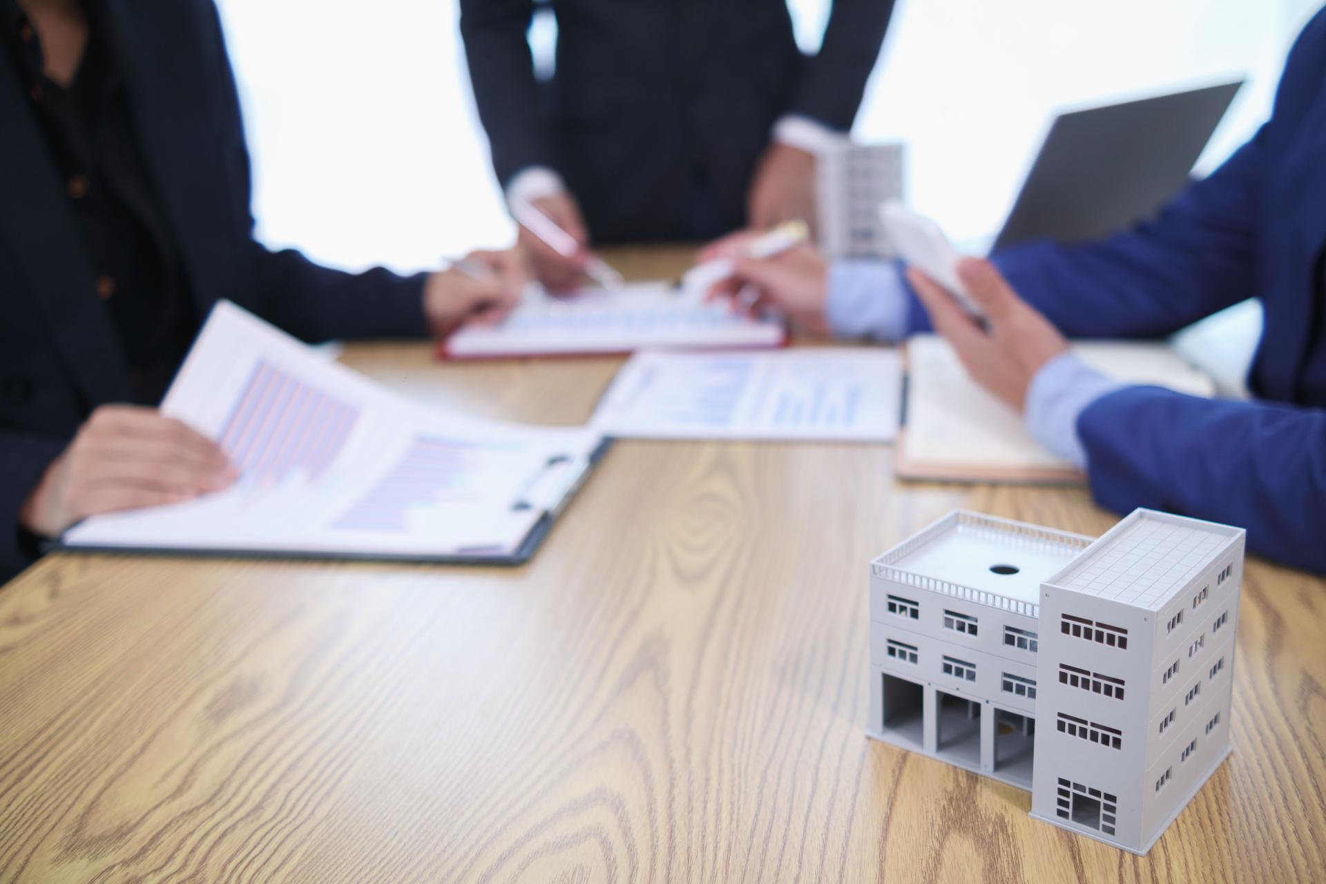 group of businessmen and investors discuss investing in real estate and jointly plan investments in construction projects of condominiums and apartments for sale and rent. investment advisory concept